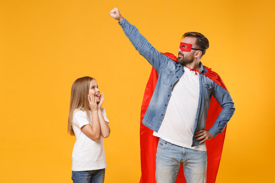 Bearded man in casual clothes Super hero costume have fun with cute child baby girl. Father little kid daughter isolated on yellow background. Love family parenthood childhood concept. Clenching fist.