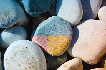 many round colored stones all equal to each other and in the middle a strange colored stone differently in pieces