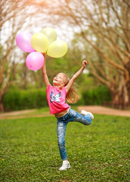 Joyful Little Girl Child Jumping From Happiness In Spring Green Park