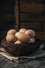 Easter organic eggs in nest on wooden background