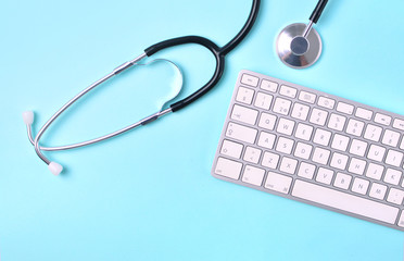 Doctor workplace. Medical stethoscope and computer keyboard top view.