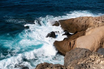 Waves of the atlantic ocean break on coastal rocks