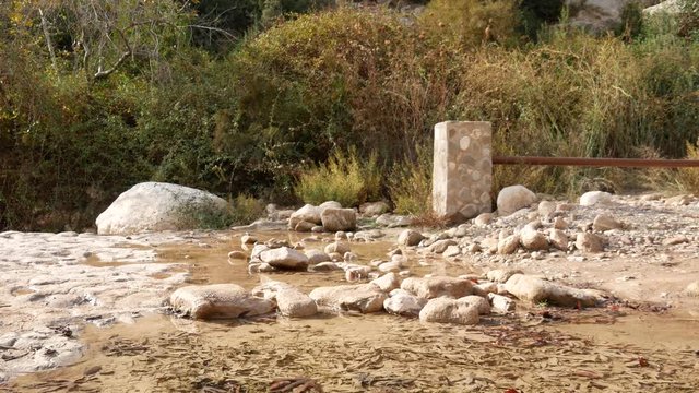 A Child Crosses A Stream Over Stones Without Wetting His Feet