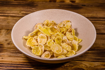 Ceramic plate with cornflakes on a wooden table. Healthy eating