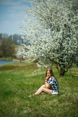 beautiful girl in a dress walking in the spring forest where the trees bloom