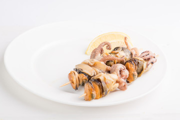 grilled seafood on a skewer on a white plate