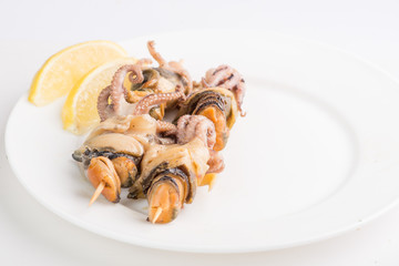 grilled seafood on a skewer on a white plate