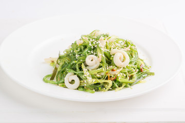chuka seaweed salad with seafood and sesame seeds on a white plate