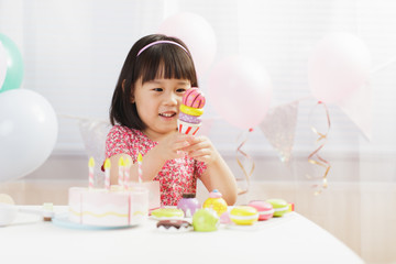 Obraz na płótnie Canvas toddler girl pretend play food preparing role at home against white background