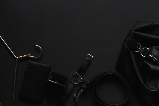 Accessories for men's beauty on a monochromatic background. Watch, perfume, belt, hanger, wallet leather. Minimal black trend 2020. Top view with copy space Flatlay.