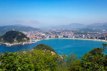 Fototapeta na wymiar View from mount Igueldo to mount Urgull and Santa Clara Island of the Bay of Biscay, San Sebastian, Donostia, Spain