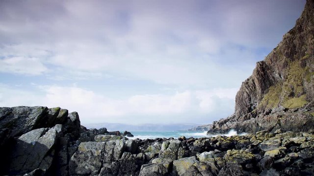 footage of the atlantic ocean as it meets the Isle of Seil on the west coast of scotland in the argyll and kintyre region showing waves pounding on the shore