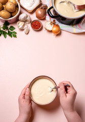 Woman hands eating cream soup. Potato and garlic soup
