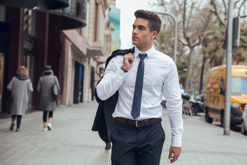 Young boy walking with white shirt and no jacket in city