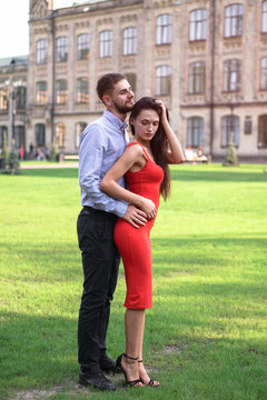 Beautiful couple of man and woman against the backdrop of a beautiful park and city architecture. Romantic theme with a girl and a guy. Spring Summer picture relationship, love, Valentine's day