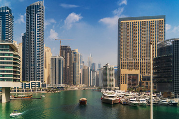 Fototapeta na wymiar Luxury Dubai Marina canal in summer day with high buildings at background, UAE emirates.