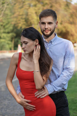 Beautiful couple of man and woman against the backdrop of a beautiful park and city architecture. Romantic theme with a girl and a guy. Spring Summer picture relationship, love, Valentine's day