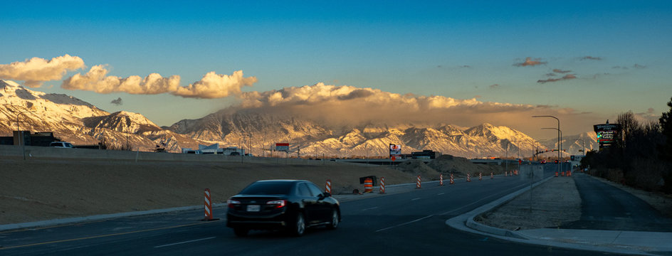 mountain range at sunset with highway in foreground