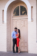 Fototapeta na wymiar Beautiful couple of man and woman on the background of a wonderful architectural solution. Romantic theme with a girl and a guy. Spring, summer photo relationship, love, Valentine's day