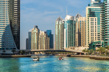 Fototapeta na wymiar Luxury Dubai Marina canal in summer day in Dubai with high buildings at background, United Arab Emirates.