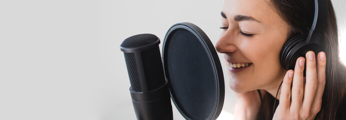 Woman blogger recording radio podcast in studio.