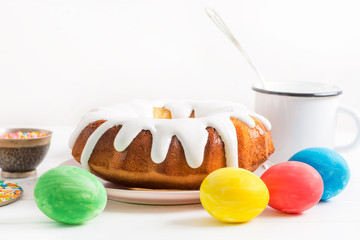 making Easter cake, spreading cream on Easter cake, sweet multi-colored topping on a white table