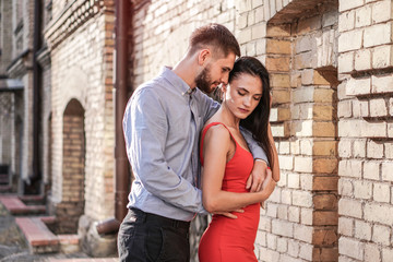 Obraz na płótnie Canvas Beautiful couple of man and woman on the background of a wonderful architectural solution. Romantic theme with a girl and a guy. Spring, summer photo relationship, love, Valentine's day