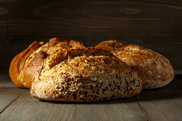 Freshly baked traditional bread on wooden table, with copy space, food closeup. Whole grain rye bread with seeds