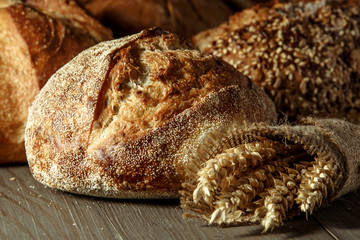 Freshly baked traditional bread on wooden table, with copy space, food closeup. Whole grain rye bread with seeds