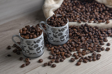 Coffee beans in coffee bag with two white cups and space for text