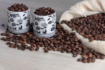 Coffee beans in coffee bag with two white cups and space for text
