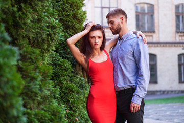 Beautiful couple of man and woman against the backdrop of a beautiful park and city architecture. Romantic theme with a girl and a guy. Spring Summer picture relationship, love, Valentine's day