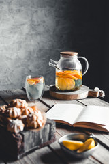 A book with citrus tea is waiting in a vintage kitchen. Rest, hobbies, education, read.