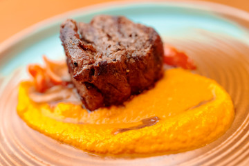 grilled steak with sauce and vegetables on white plate