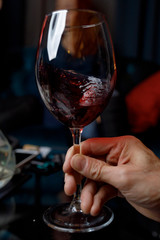 hand with glass of red wine