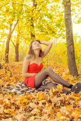 A woman is posing in front of a camera in an autumn park. autumn photo shoot. Autumn in the park.