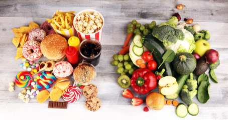 healthy or unhealthy food. Concept photo of healthy and unhealthy food. Fruits and vegetables vs donuts,sweets and burgers - 327953305