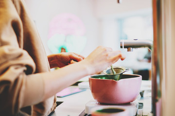 Professional barista preparing japanese matcha tea using organic ingredients and modern teaware...