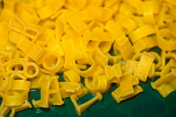 macaroni alphabet letters on a green plate.