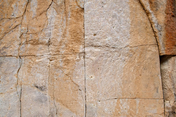 Square Cracked Volcanic Tuff Rock Natural Background Pattern with a design of straight lines forming squares that look like a quarry