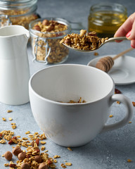 Homemade granola from mix of oat cereals  with dry fruits, nuts and seeds on a grey  concrete table concept of healthy breakfast. Slow living