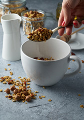 Homemade granola from mix of oat cereals  with dry fruits, nuts and seeds on a grey  concrete table concept of healthy breakfast. Slow living