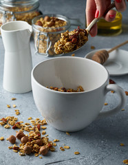 Homemade granola from mix of oat cereals  with dry fruits, nuts and seeds on a grey  concrete table concept of healthy breakfast. Slow living