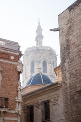Fototapeta na wymiar Cathedral tower framed by historic houses in Valencia, Spain