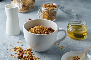 Homemade granola from mix of oat cereals  with dry fruits, nuts and seeds on a grey  concrete table concept of healthy breakfast. Slow living