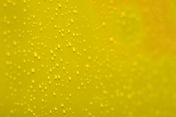 soft focus water drops on vivid yellow perspective surface wallpaper background concept 