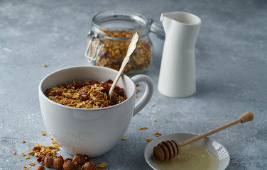 Homemade granola from mix of oat cereals  with dry fruits, nuts and seeds on a grey  concrete table concept of healthy breakfast. Slow living
