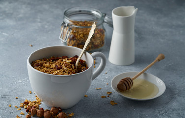 Homemade granola from mix of oat cereals  with dry fruits, nuts and seeds on a grey  concrete table concept of healthy breakfast. Slow living