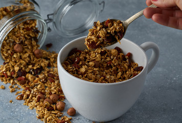 Homemade granola from mix of oat cereals  with dry fruits, nuts and seeds on a grey  concrete table concept of healthy breakfast. Slow living