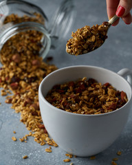 Homemade granola from mix of oat cereals  with dry fruits, nuts and seeds on a grey  concrete table concept of healthy breakfast. Slow living